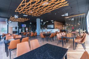 een restaurant met tafels en stoelen en een bar bij Hotel Tierra in Don Benito
