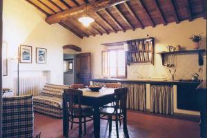 a kitchen and living room with a table and a couch at Casa Ercole Farm Stay in Greve in Chianti