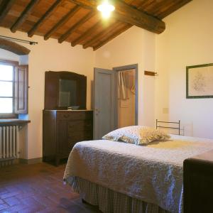 sypialnia z łóżkiem, komodą i telewizorem w obiekcie Casa Ercole Farm Stay w Greve in Chianti