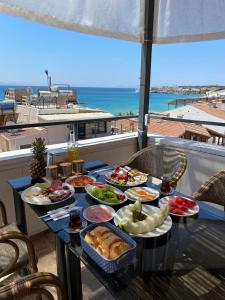 ein Tisch mit Tellern voller Essen auf einem Balkon in der Unterkunft Acer Güneş Otel in Didim