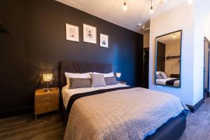 a bedroom with a large bed and a mirror at Veyron Apartments - part of the V Group in Blackpool