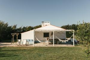 Maria Vinagre的住宿－Casa da Maria • Natural Côte • Aljezur，一座带帐篷的大型白色建筑