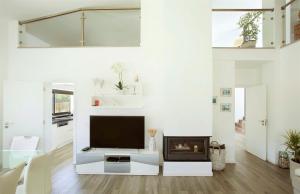 sala de estar con TV y chimenea en The White Villa by The Getaway Collection, en Carvalhal