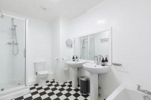 a bathroom with two sinks and a toilet and a shower at Beachside Retreat 2-Bedroom Gem with FREE Private Parking & Outdoor Space in Brighton & Hove