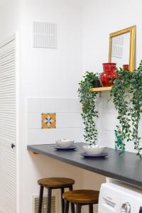 a kitchen with two stools and a counter with plants at Beachside Retreat 2-Bedroom Gem with FREE Private Parking & Outdoor Space in Brighton & Hove