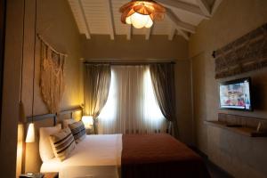 a bedroom with a bed with a window and a television at ASHA ALAÇATI in Çeşme +44 photos