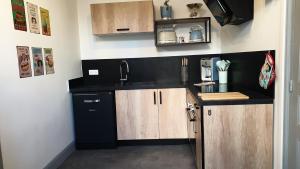 uma cozinha com armários de madeira e um lavatório em Le Loft Vintage Epernay avec Netflix, Vélos, Parking gratuit em Épernay