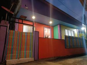 una casa colorida con una valla delante en El Nido Home Stay, en El Nido