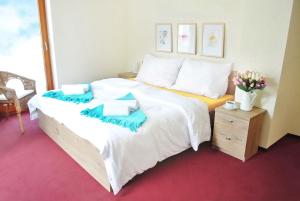 um quarto com uma cama grande com lençóis azuis e brancos em Penzion Trnka em Potštejn
