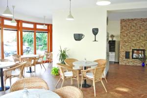 a restaurant with tables and chairs and a fireplace at Penzion Trnka in Potštejn