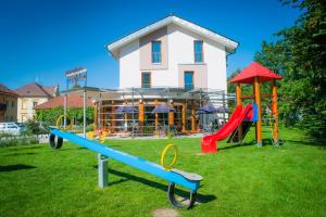 a playground with slides in front of a building at Penzion Trnka in Potštejn