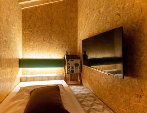 een kleine kamer met een bed en een televisie bij eeGee STAY Kamata in Tokyo