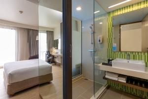 a bathroom with a bed and a sink and a shower at Holiday Inn Express Bangkok Sukhumvit 11 by IHG in Bangkok