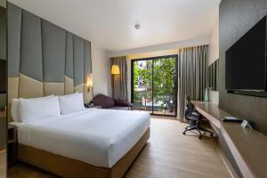 ein Hotelzimmer mit einem großen weißen Bett und einem Schreibtisch in der Unterkunft Holiday Inn Express Bangkok Sukhumvit 11, an IHG Hotel in Bangkok
