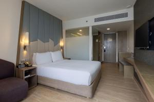 a bedroom with a large white bed and a couch at Holiday Inn Express Bangkok Sukhumvit 11 by IHG in Bangkok +103 photos