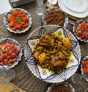 Villa Le Clos de l'Atlas في مراكش: طاولة مع أطباق من الطعام على طاولة