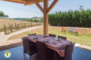 a table and chairs on a patio with a table and chairs at Le Val des Sens in Chatte