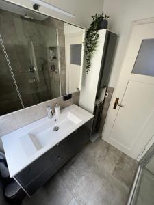 ein Badezimmer mit einem weißen Waschbecken und einem Spiegel in der Unterkunft Zentrale 3 Zimmer Wohnung - Nähe Flughafen & Messe in Neuhausen auf den Fildern