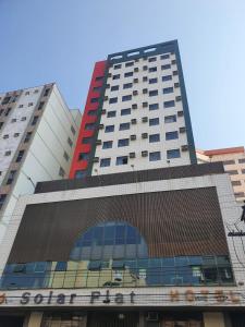 un edificio blanco alto con un letrero. en Solar Flat Hotel en Juiz de Fora