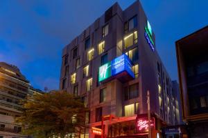 a building with neon signs on the side of it at Holiday Inn Express Bangkok Sukhumvit 11, an IHG Hotel in Bangkok