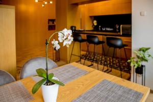 una mesa de madera con un jarrón con flores. en Rose Gold Apartment en Zalaegerszeg