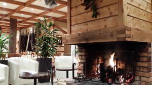 Una chimenea en una habitación con sillas y mesa. en Hôtel du Hameau en La Foux