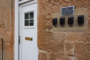 een deur naar een gebouw met een bord dat de koffie leest bij Signature - Linden Cottage Room 2 in Airdrie
