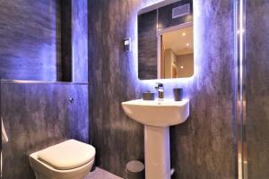 une salle de bain avec un lavabo, des toilettes et un miroir dans l'établissement Signature - Linden Cottage Room 2, à Airdrie 10 autres photos