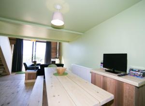 a living room with a wooden table and a flat screen tv at Tarset Tor - Bothy 1 in Greenhaugh