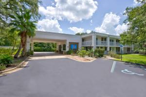 un gran edificio blanco con entrada en Motel 6-Gainesville, FL, en Gainesville