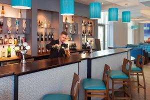 a bartender preparing a drink at a bar at Leonardo Hotel Plymouth - Formerly Jurys Inn in Plymouth