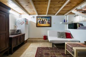 a living room with a white couch and a refrigerator at Ahuzat Shaul - Apartment in H̱adera