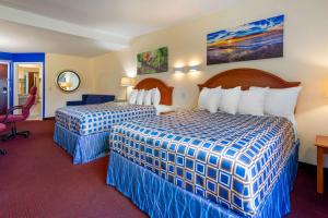 a hotel room with two beds and a desk at Rodeway Inn & Suites New Paltz - Hudson Valley in New Paltz