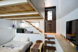 a room with a bed and a staircase and a tv at Ahuzat Shaul - Apartment in H̱adera