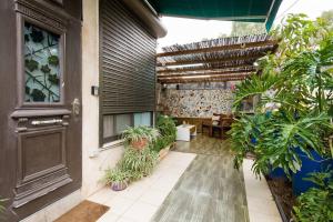una casa con un patio con plantas y una puerta en Ahuzat Shaul - Apartment en H̱adera