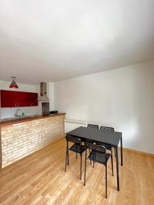een keuken met een tafel en 2 stoelen in een kamer bij PoNSARDIN - Bel appartement avec balcon et Parking in Reims