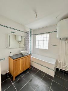 een badkamer met een bad, een wastafel en een bad bij PoNSARDIN - Bel appartement avec balcon et Parking in Reims
