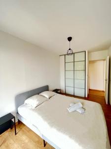 a white bed in a room with a window at PoNSARDIN - Bel appartement avec balcon et Parking in Reims
