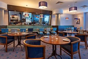 um restaurante com mesas e cadeiras e um bar em Leonardo Hotel Plymouth em Plymouth