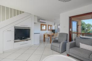 a living room with a tv and a couch and chairs at San Lameer Villa 2832 - 3 Bedroom Classic - 6 pax - San Lameer Rental Agency in Southbroom