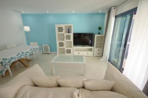 een woonkamer met een bank en een tv bij Livingtarifa Sugar in Tarifa