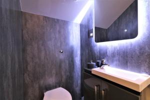 a bathroom with a sink and a toilet and a mirror at Signature - Linden Cottage Room 4 in Airdrie