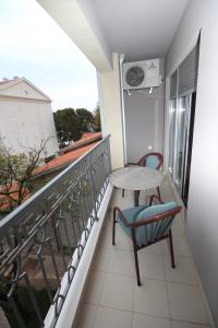 a balcony with a table and a chair and a window at Apartments Oaza 2 in Petrovac na Moru