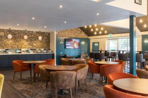 a restaurant with tables and chairs and a bar at Almondsbury Inn & Lounge in Almondsbury
