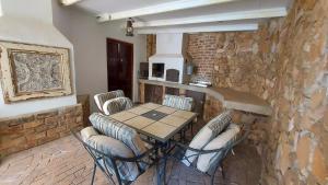 a table and chairs in a room with a stone wall at Bluebell Cottage in Dullstroom