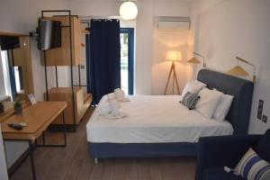 a bedroom with a bed and a desk and a television at Christina Studios & Apartments in Parga