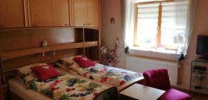 a bedroom with a bed and a table and a window at Haus Edda Einfamilienhaus in Gundersheim