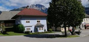 a white house with a red roof with a mountain in the background at Haus Edda Einfamilienhaus in Gundersheim