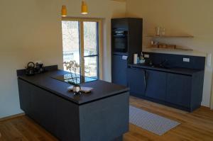 a kitchen with blue cabinets and a black counter top at Waldheimat in Miltach +32 photos