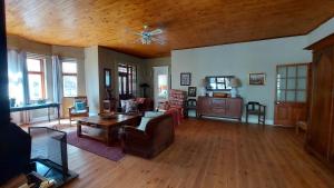 Bluebell Country House في دولستروم: غرفة معيشة مع مروحة سقف وأرضيات خشبية